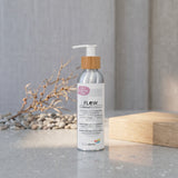 A bottle of Biotaderm Flow Oily Sensitive Light Moisturiser with a pump dispenser stands on a stone surface amid pebbles, wood, and dried plant decor in natural light. Enriched with nourishing plant oils, this lightweight facial moisturiser is ideal for oily, sensitive skin.